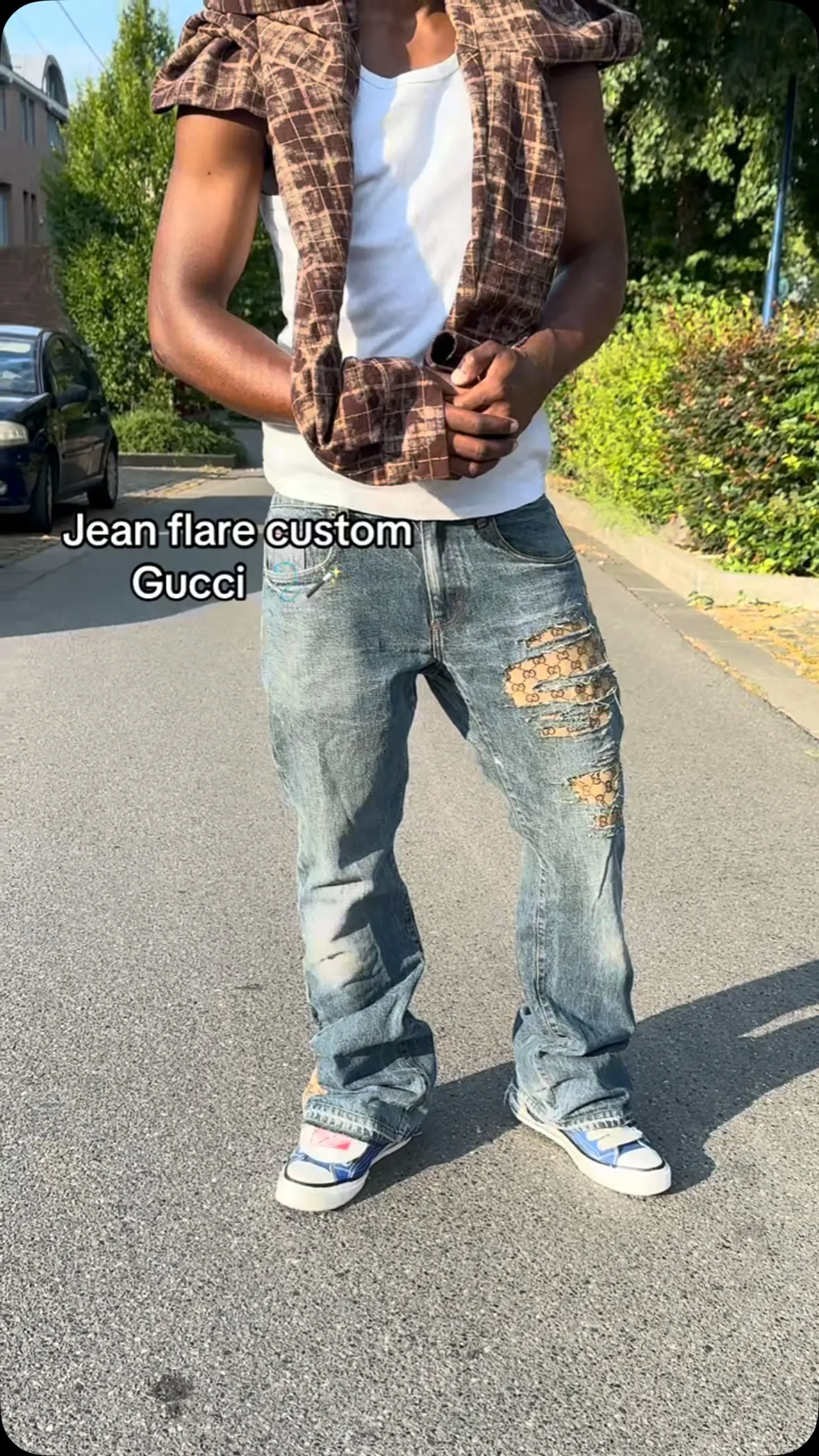 Jean custom devant un mur de briques